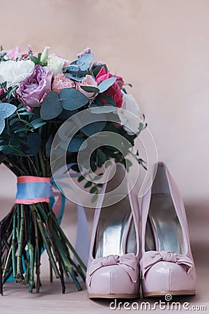 Beautiful wedding shoes with high heels and a bouquet of colorful flowers Stock Photo