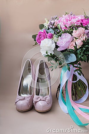 Beautiful wedding shoes with high heels and a bouquet of colorful flowers Stock Photo