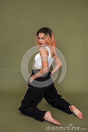 beautiful well-groomed woman posing boldly on a solid green studio background. Stock Photo