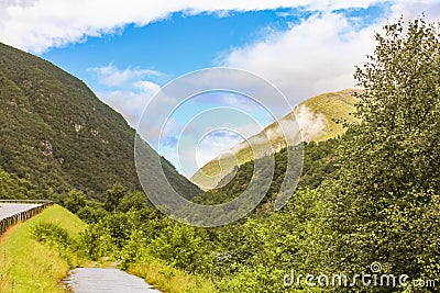 Beautiful wet road the mountains cloudy sky of Norway Stock Photo