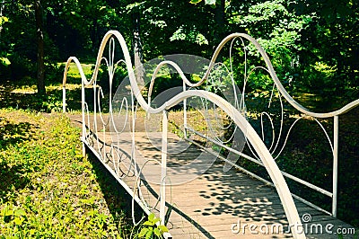 The white forged bridge in a garden Stock Photo