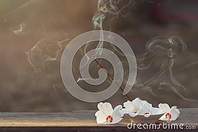 Beautiful white jasmine flowers and incense sticks with smoke for outdoor spiritual practices. Horizontal format Stock Photo