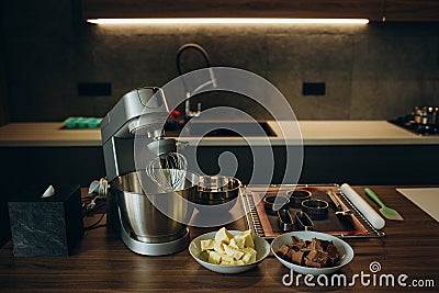 A beautiful white mixer with a metal cup stands in the modern kitchen. Stock Photo