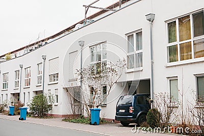 Beautiful white two-storey house with bushes and garbage cans and parked car. Germany. Stock Photo