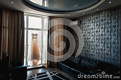Beautiful White Wedding Gown Hanging by Window Stock Photo