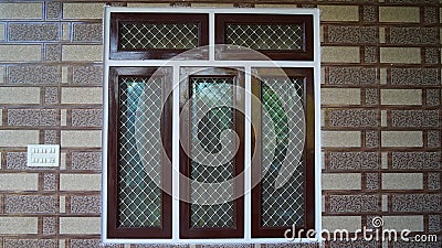 Beautiful window fence fitted in wall. Stylish modern building window with aluminium window pattern Stock Photo