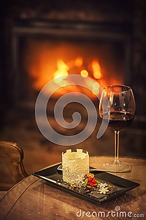 Beautiful winter dessert like castle with snowflakes and fruits served on white plate with glass of red wine, product photography Stock Photo