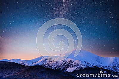 Beautiful winter landscape in the Carpathian mountains. Vibrant night sky with stars and nebula and galaxy. Deep sky Stock Photo
