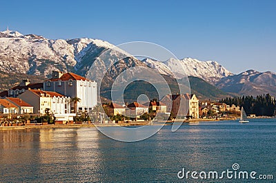 Beautiful winter Mediterranean landscape. Montenegro, Kotor Bay. View of embankment of Tivat city and snowy mountains of Lovcen Stock Photo