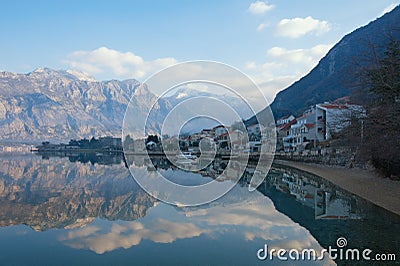 Beautiful winter Mediterranean landscape - mountains, blue sky with white clouds and reflection in the water. Montenegro Stock Photo