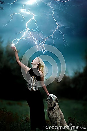 Beautiful witch girl controls lightning strike Stock Photo