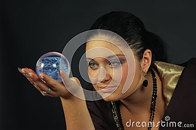 Beautiful witch with magic sphere Stock Photo