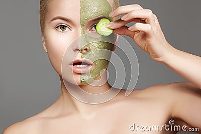 Beautiful Woman Applying Green Facial Mask. Beauty Treatments. Close-up Portrait of Spa Girl Apply Clay Facial mask Stock Photo