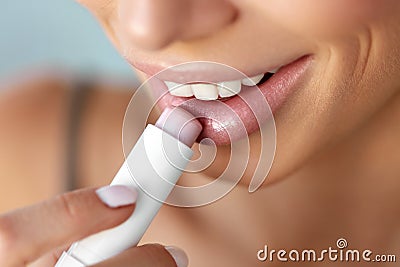 Beautiful Woman Applying Lip Protector On Lips Skin. Beauty Stock Photo