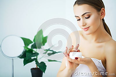 A beautiful woman using a skin care product, moisturizer or lotion and Skincare taking care of her dry complexion. Moisturizing c Stock Photo