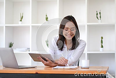 Beautiful woman Asian using digital tablet work at the office. Stock Photo