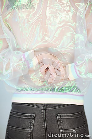 Beautiful woman back, hands and arms wearing a sweater with holographic effect, modern avantgarde artificial plastic look Stock Photo