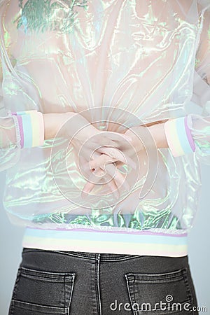 Beautiful woman back, hands and arms wearing a sweater with holographic effect, modern avantgarde artificial plastic look Stock Photo