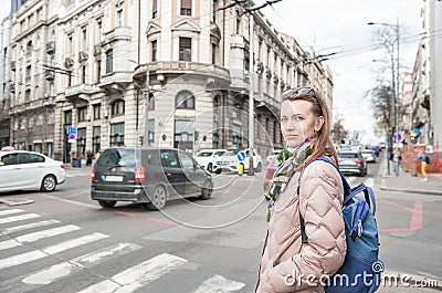 Beautiful woman with bagpack and sunglasses standing on the street in the Belgrade city, Serbia Stock Photo