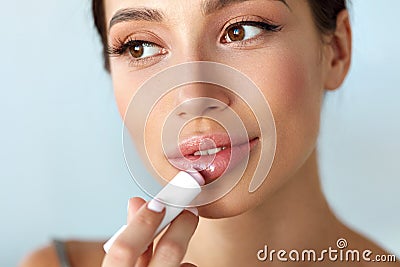 Beautiful Woman With Beauty Face Applies Balm On Lips. Skin Care Stock Photo