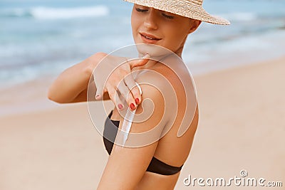 Beautiful Woman in Bikini Applying Sun Cream on Tanned Shoulder. Sun Protection. Stock Photo