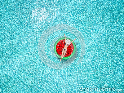 Beautiful woman in a bikini enjoys the tropical sun on a watermelon shaped float Stock Photo