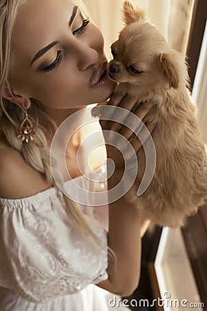 Beautiful woman with blond hair with cute little dog Stock Photo