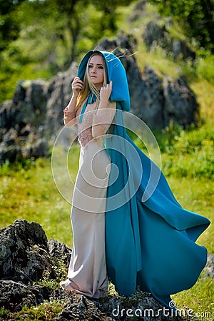 Beautiful woman with blue cloak posing Stock Photo
