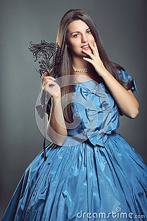 Beautiful woman with blue dress and black mask Stock Photo