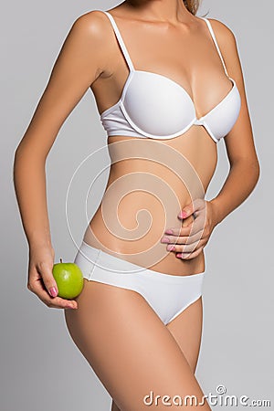 Beautiful woman body and green apple. Conceptual image of dieting healthy lifestyle Stock Photo