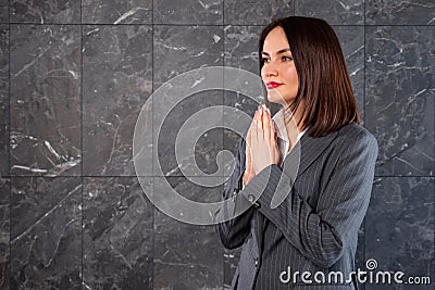 Beautiful woman in business gray suit looking with supplication at copy space Stock Photo