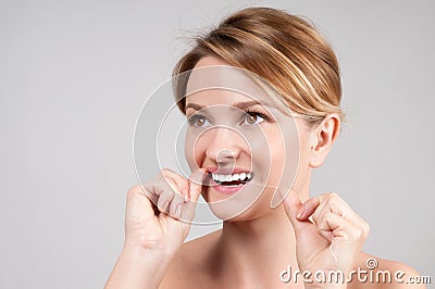 Beautiful woman cleaning teeth with dental floss Stock Photo