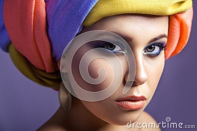 Beautiful woman with colored headwear and blue makeup. Stock Photo