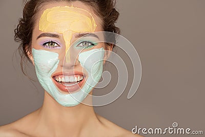 Beautiful woman with colorful cream mask on her face Stock Photo