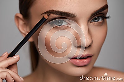 Beautiful Woman Contouring Eyebrows With Pencil. Beauty Stock Photo