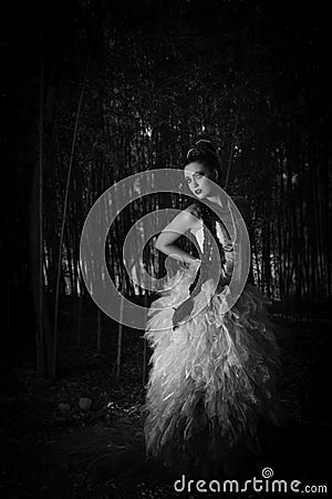 Beautiful woman in couture dress standing in a forest Stock Photo