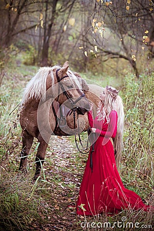 Beautiful woman in crown, blonde with horse. Princess in fairy tale. Stock Photo