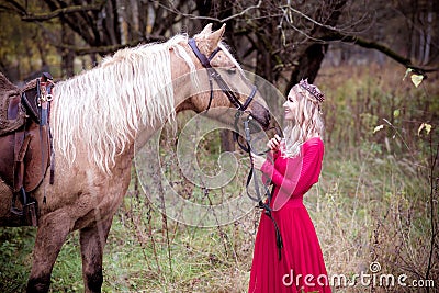 Beautiful woman in crown, blonde with horse. Princess in fairy tale Stock Photo