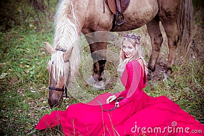 Beautiful woman in crown, blonde with horse. Princess in fairy tale. Stock Photo