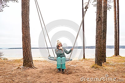 Beautiful woman with cup on Swing Stock Photo