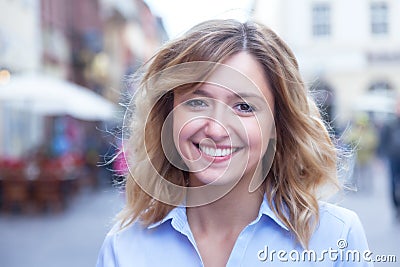 Beautiful woman with curly blond hair in the city Stock Photo