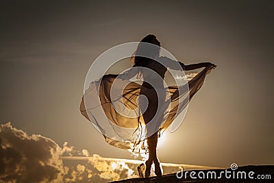 Beautiful woman dancing at sunset Stock Photo