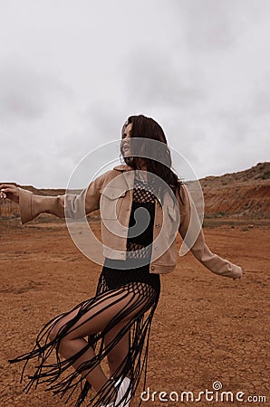 beautiful woman with dark hair in casual clothes posing in desert of Cyprus Stock Photo