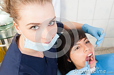 Beautiful woman dentist examining female patient teeth Stock Photo