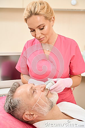 Beautiful woman dermatologist doing ultrasound facelift smas lifting Stock Photo