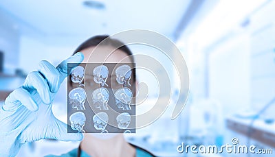 Beautiful woman doctor radiologist, oncologist looks at MRI images of a child. Soft blurred clinic background Stock Photo