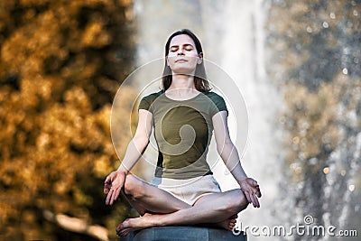 Beautiful woman doing yoga pose in the city park and enjoy healthy lifestyle Stock Photo