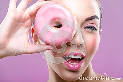 Beautiful woman with donuts, one eye than have a pink donut Stock Photo