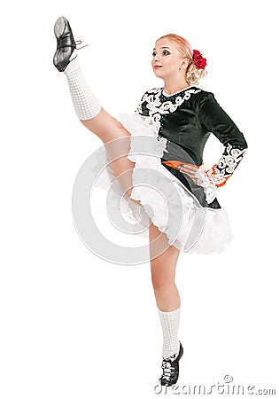 Beautiful woman in dress for Irish dance with leg up isolated Stock Photo