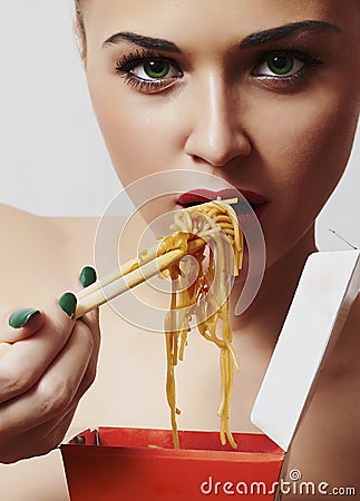 Beautiful woman are eating noodles.red lips.Chinese sticks. fast food.food delivery Stock Photo